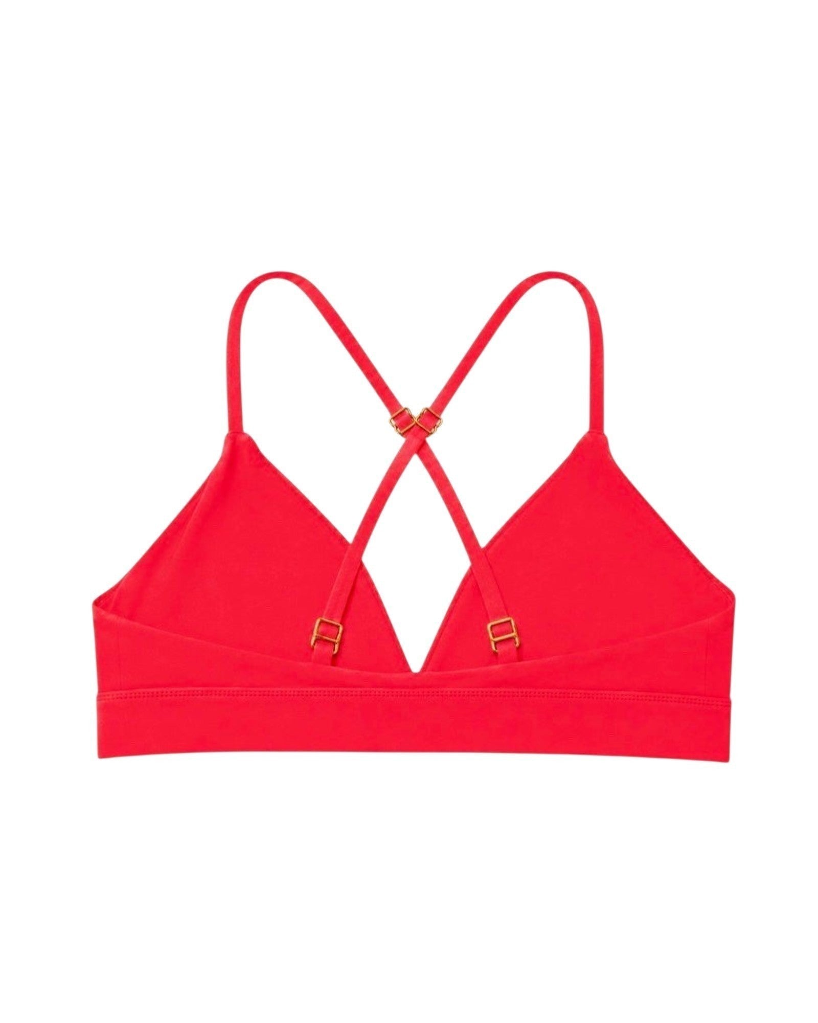 Phural coral riviera sports bra with a crisscross back design and gold-tone hardware on a white background.