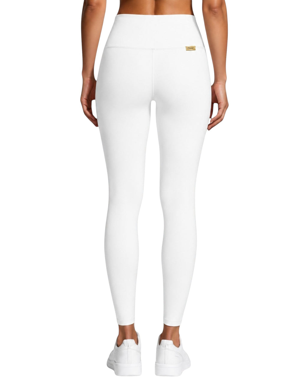 Back view of Phural white high-waisted performance leggings with a small gold logo tag, worn with white sneakers.
