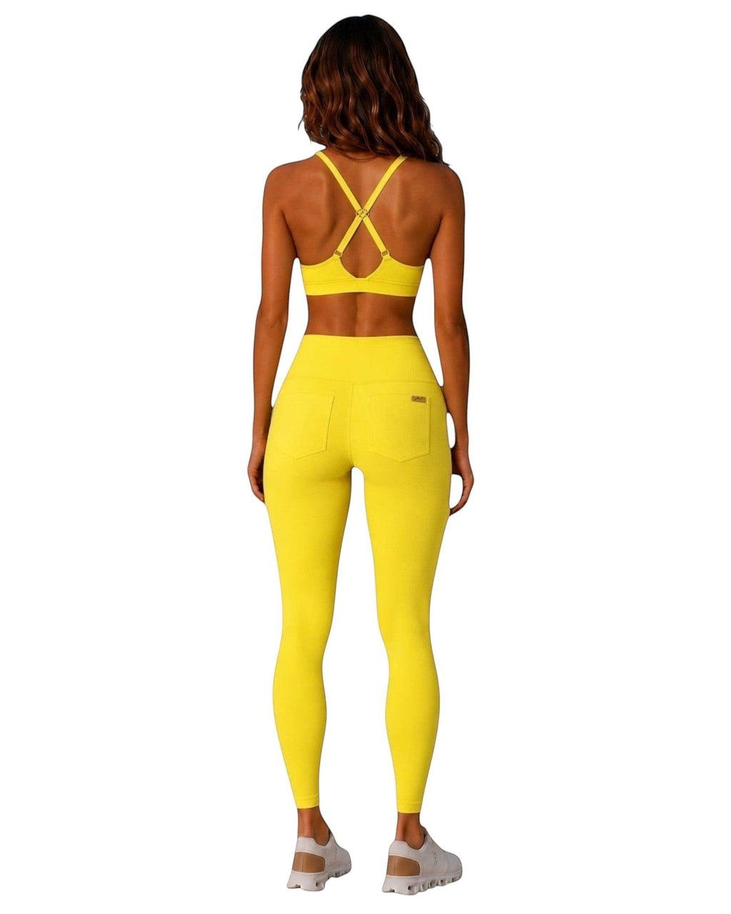Back view of a model wearing the yellow Cardio To Cabana Bra-kini, showing X-shaped straps above matching leggings.