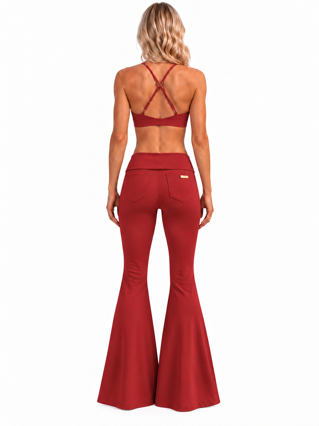 Rear view of Phural's blonde model in Rouge Noir She Did It Anyway Flares, showing the low-rise fold-over waistband, two back pockets and small gold tag.